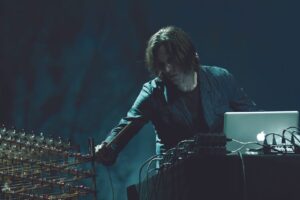 Fennesz live con laptop e chitarra — performance di musica elettronica sperimentale