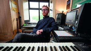 Synkro nel suo studio con sintetizzatori Juno-6 e SH-101