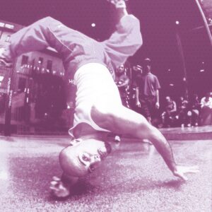 B-Boy in footwork dinamico su pavimento urbano, stile Power Footwork