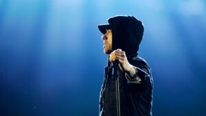 Eminem ripreso di profilo sul palco avvolto dalle luci blu del concerto
