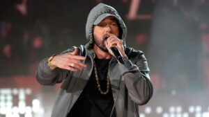 Eminem canta dal vivo con cappuccio grigio e catena dorata