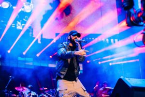 Eminem sul palco durante un concerto dal vivo con luci blu e rosa