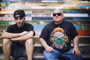 Ice One insieme al rapper Don Diegoh seduti su una scalinata colorata