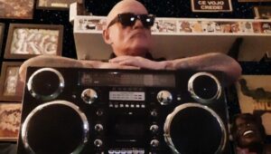 Ice One oggi dietro un boombox vintage circondato da vinili e memorabilia Hip Hop