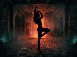 Ballerina in tacchi a spillo in posa scenica tra luci rosse in un ambiente underground suggestivo