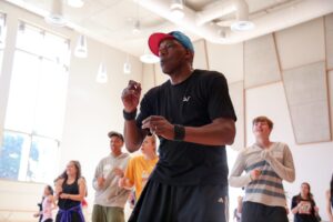 Anthony Thomas durante una lezione di danza Hip Hop in una sala luminosa, circondato dai partecipanti
