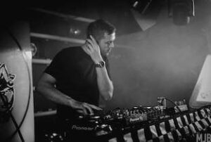 Culprate dietro la consolle durante un DJ set, in bianco e nero