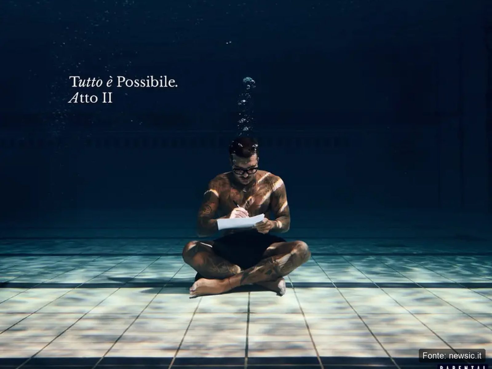 Geolier Winner Artwork Tutto E Possibile Atto 2 2026 Artwork di Tutto è possibile Atto 2 di Geolier, il rapper seduto sul fondo di una piscina