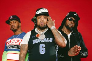 Tre rapper dei Griselda in posa su sfondo rosso, con cappelli, catene e maglia con scritta Buffalo