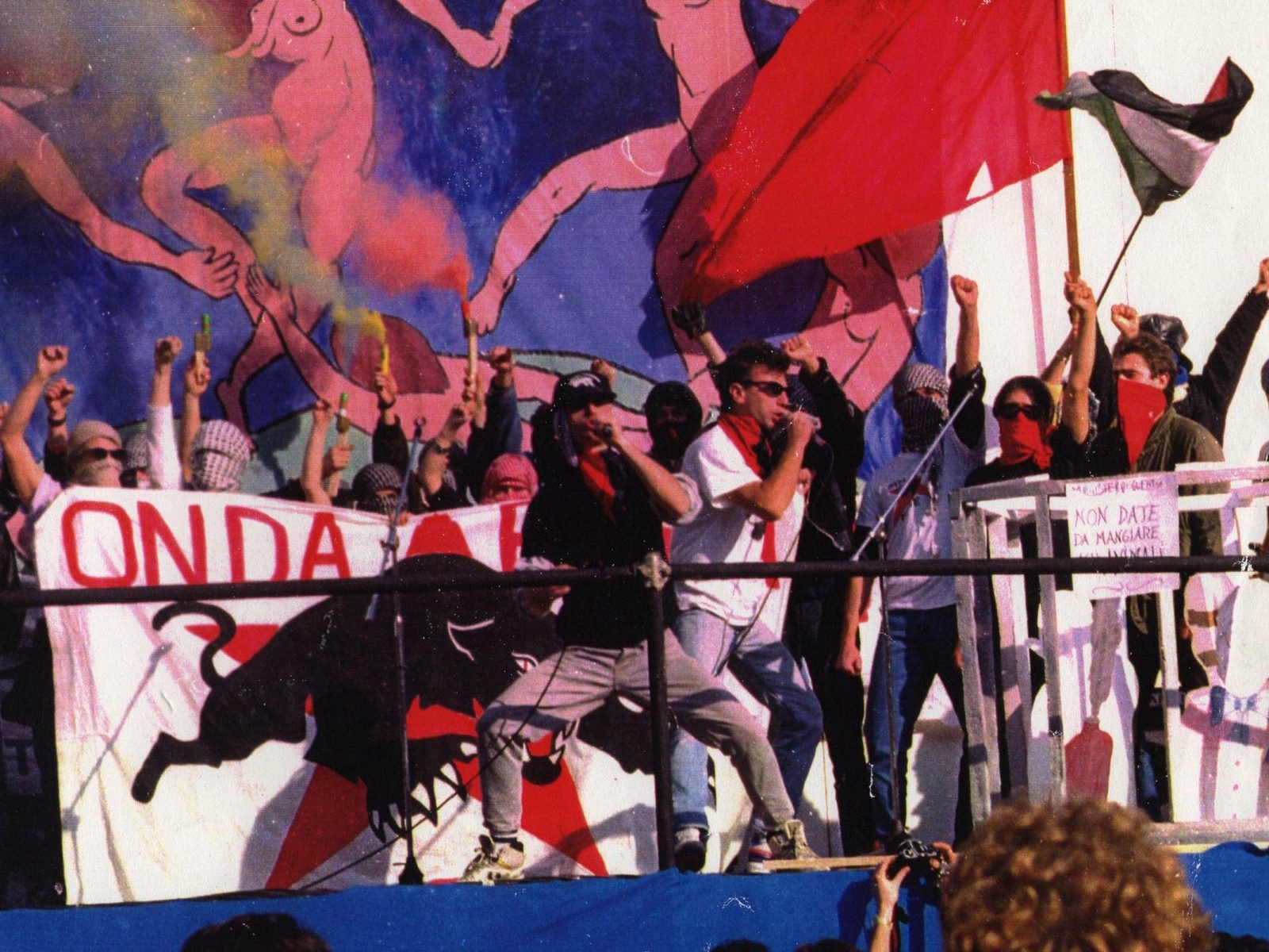 Onda Rossa Posse Concerto Storico 1990 Gli Onda Rossa Posse sul palco nel 1990 davanti allo striscione con la pantera nera, tra bandiere rosse e pugni alzati