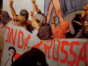 Militanti con la kefiah dietro lo striscione di Radio Onda Rossa, la radio libera di San Lorenzo a Roma