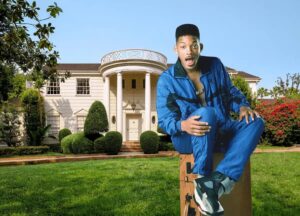 Will Smith in tuta blu seduto su una valigia davanti alla villa dei Banks a Bel-Air, location di Willy, il principe di Bel-Air